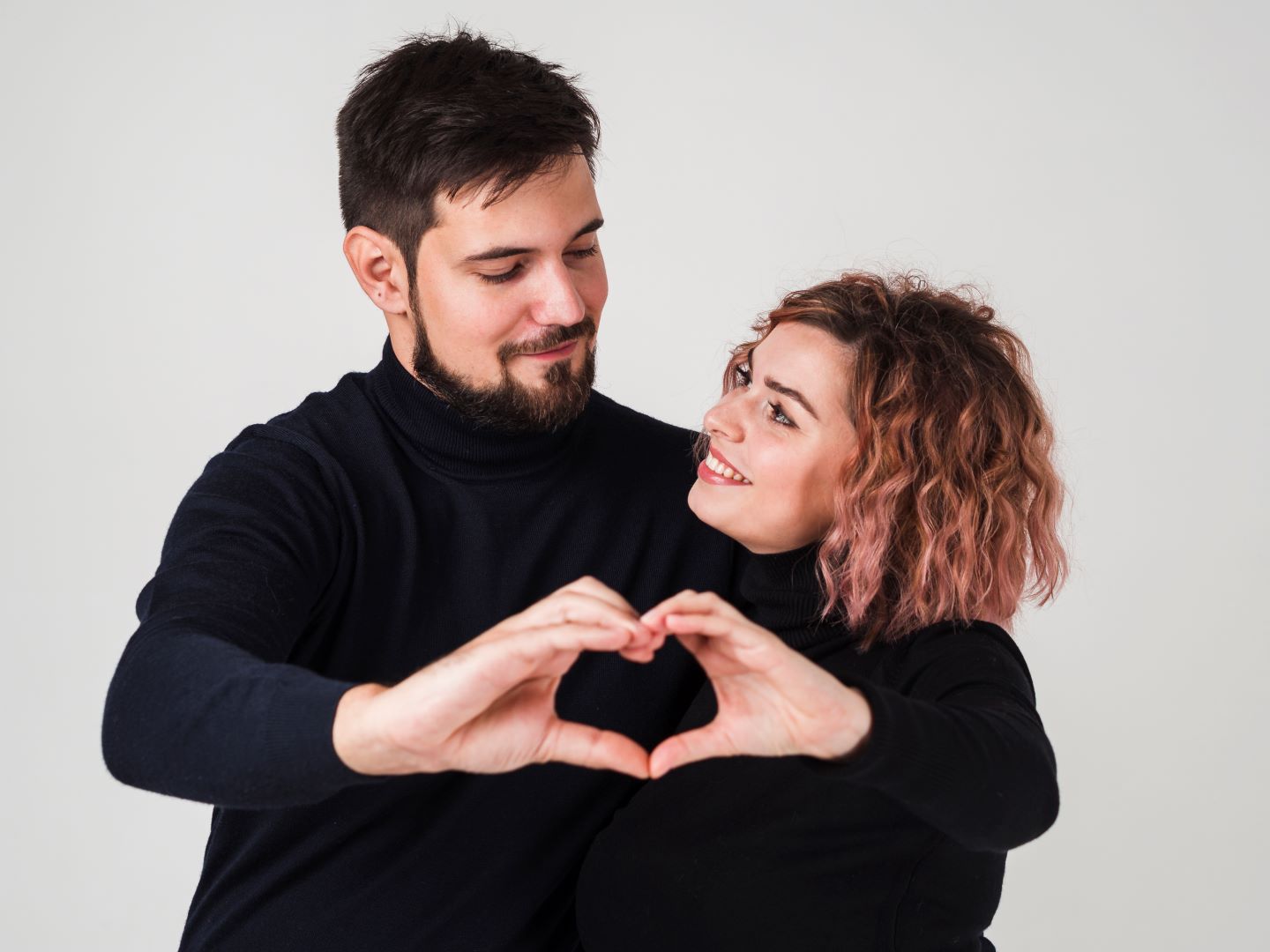 خطيبان يكونان معاً بيديهما شكل قلب ويبتسمان بسعادة   