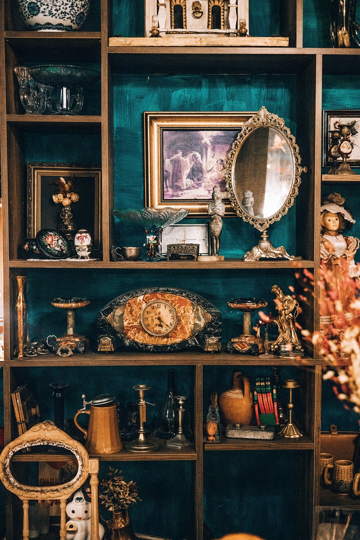 تحف صغيرة فينتاج وساعات قديمة موزعة في خزانة خشبية