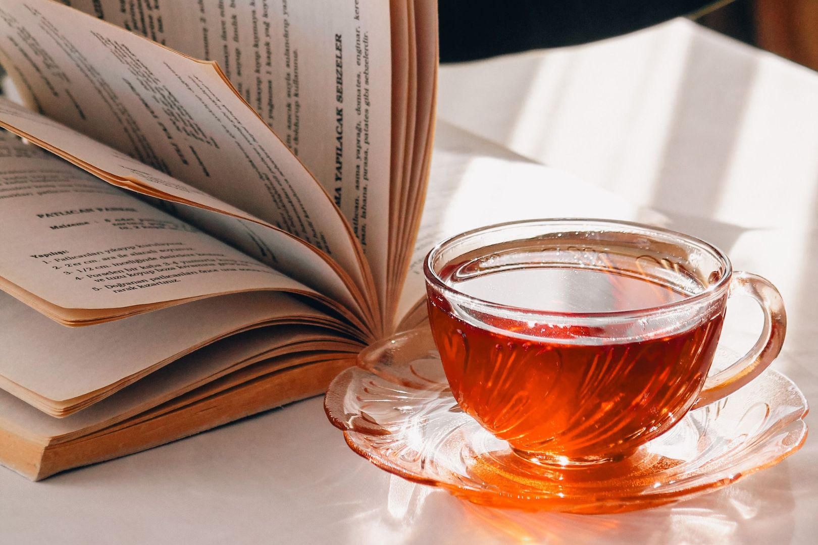  الشاي رفيق الصباح المنعش وبجانبه كتاب مفتوح