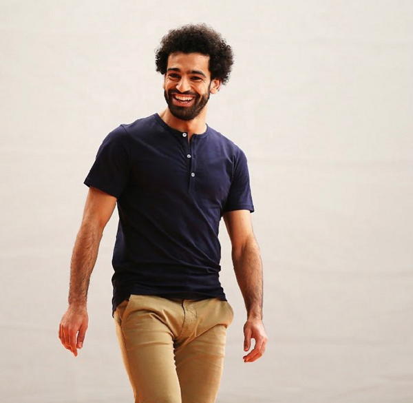 محمد صلاح يرتدي سروال باللون البيج مع تيشيرت كحلي