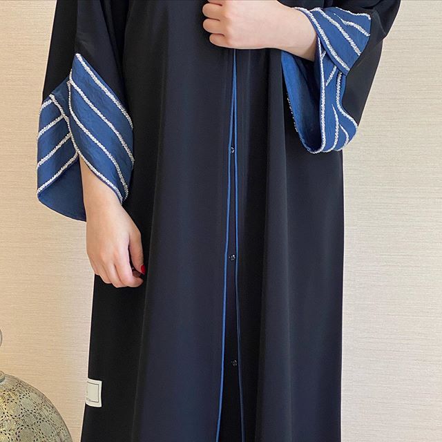 العبايه باللون الكحلي مع الأكمام المخططة