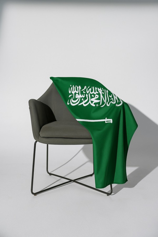 مقعد جانبي في غرفة المعيشة مع علم المملكة العربية السعودية المشاركة في مونديال 2026