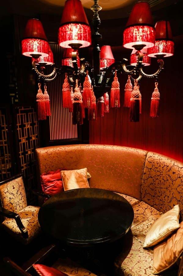 ثريا فاخرة ذات شراشيب بلون أحمر دم الغزال فوق مجلس فخم