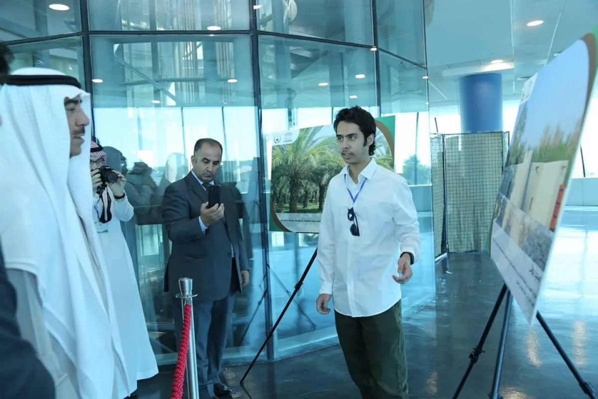 أحد الطلبة السعوديين يقدم شرحاً للملحق الثقافي عن المعرض.jpg