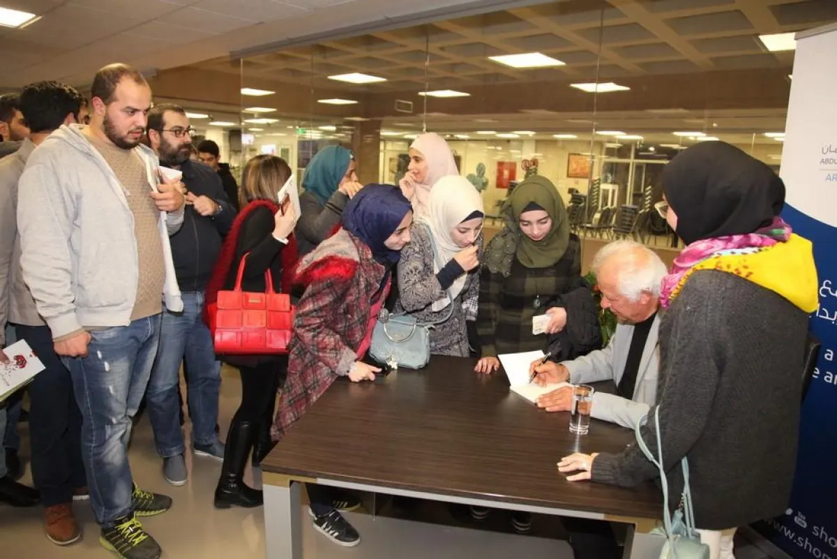 مريد البرغوثي يوقع ديوانه للحضور.jpg