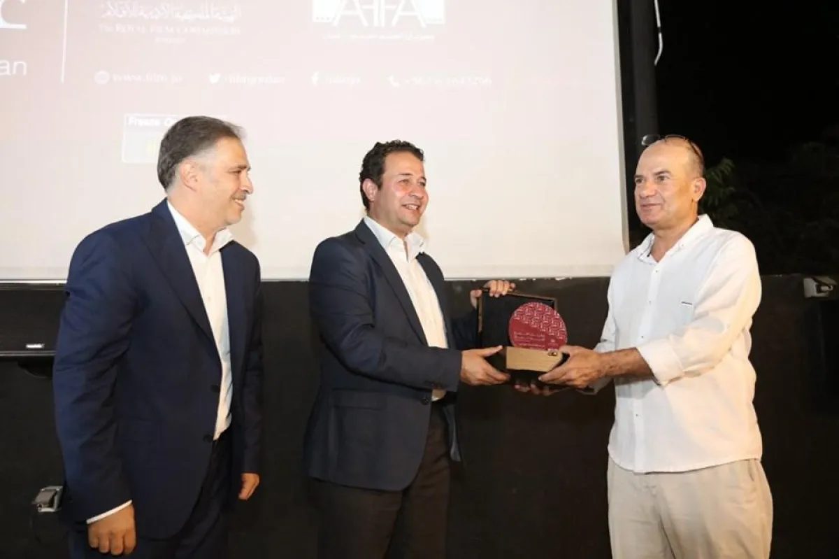 الناقد ناجح حسن يتسلم درع التكريم.jpg