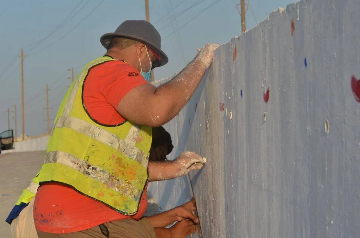 رسام تشكيلي أثناء القيام بالمشاركة في رسم الجدارية