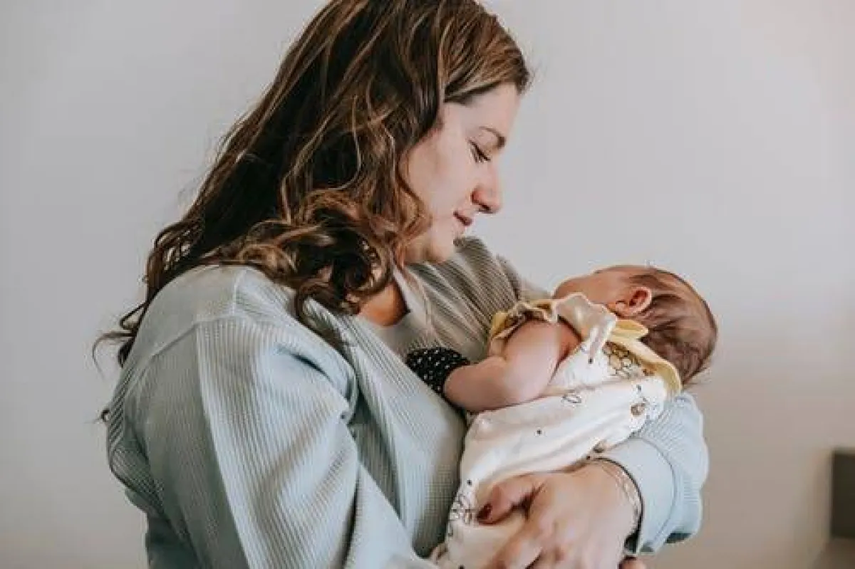 صورة لرضيع ينام بين ذراعي أمه