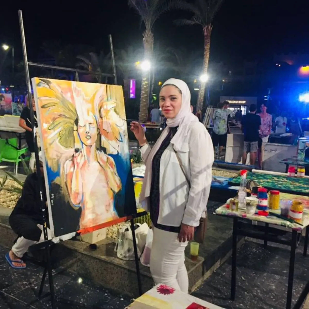 تشكيلية أمام لوحتها 