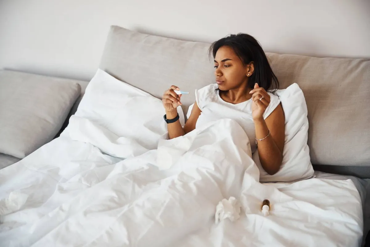 صورة لامرأة تقيس درجة حرارتها