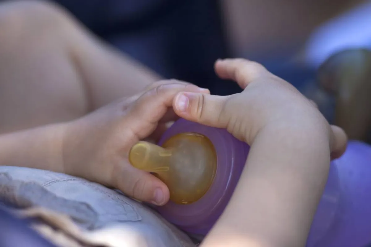 صورة طفل في الفراش مع زجاجة الحليب