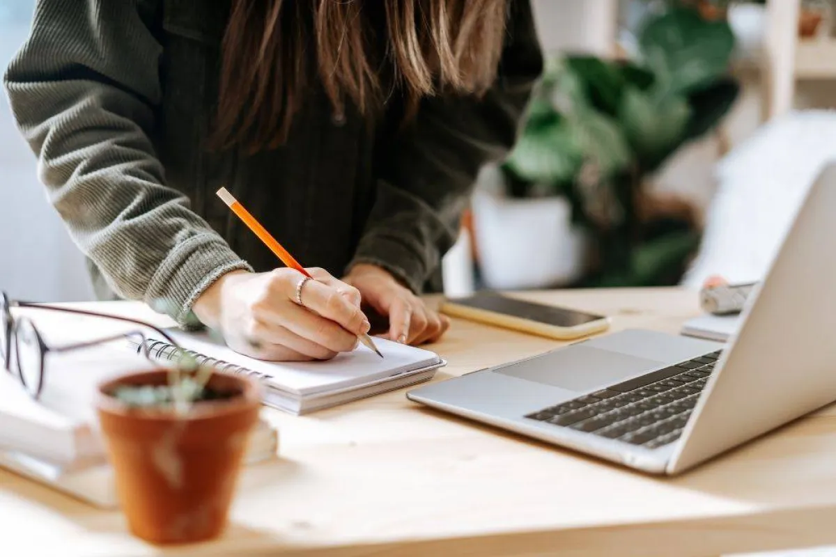 صورة فتاة تكتب في دفتر