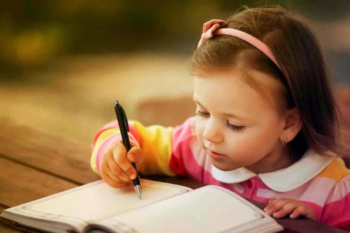 صورة لطفلة مع الورق والقلم