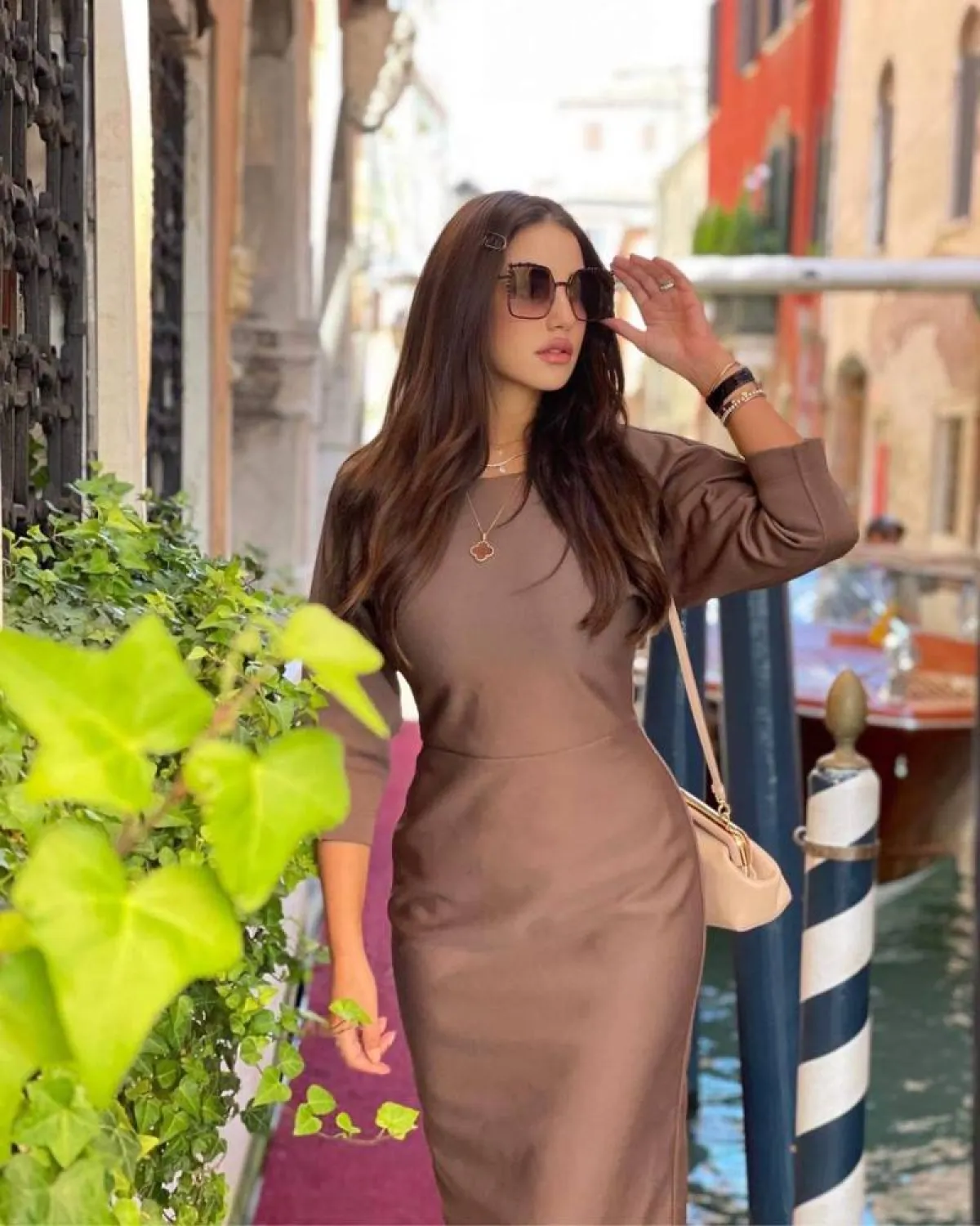 درة بفستان بني مع حقيبة ونظارة شمسية من فيندي Fendi