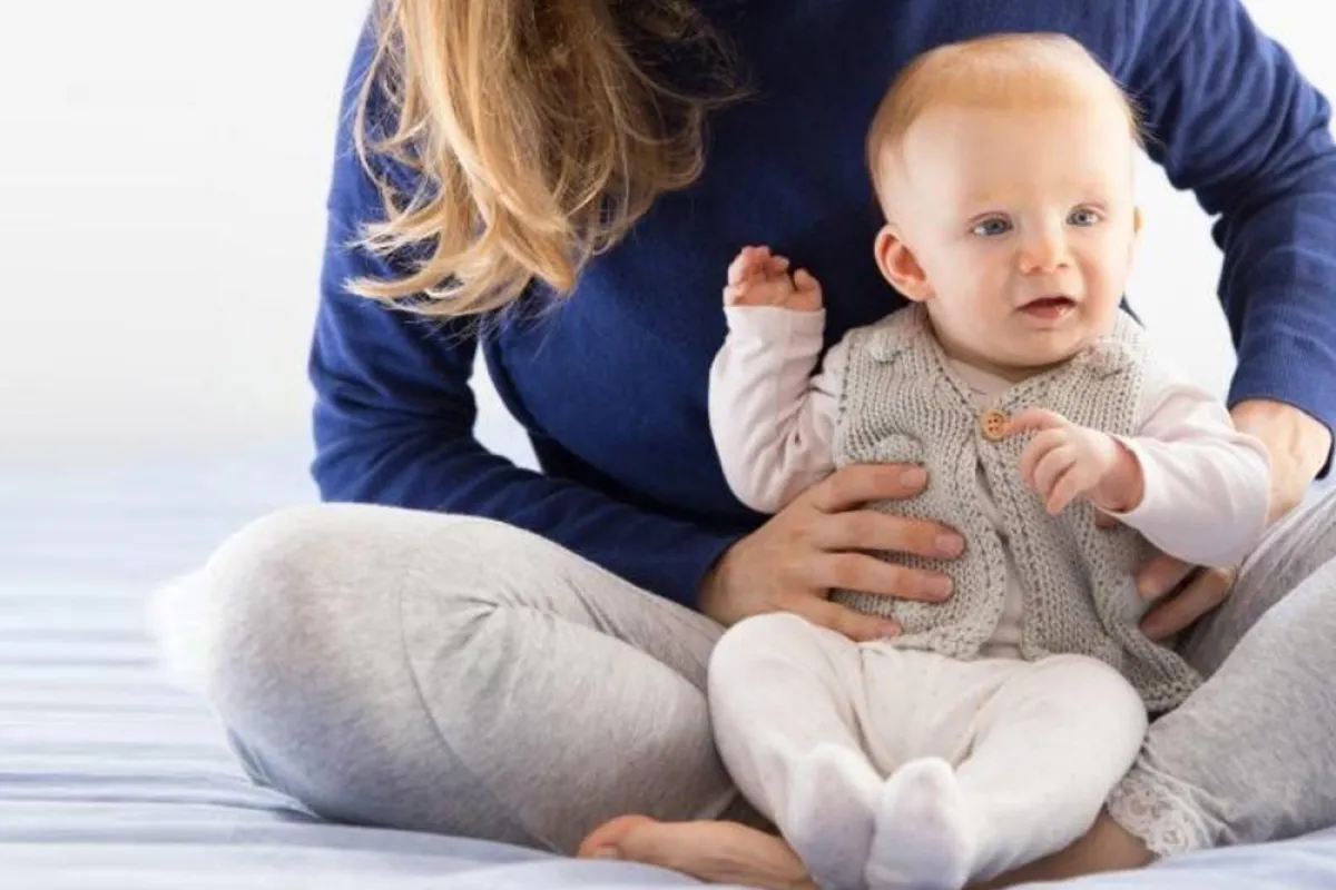 صورة لرضيع يجلس بمساندة الأم