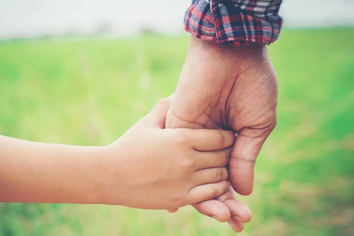 صورة لأب يمسك يد طفله