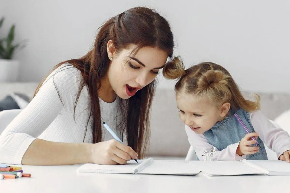 صورة لطفلة مع والدتها وهي تعلمها النطق