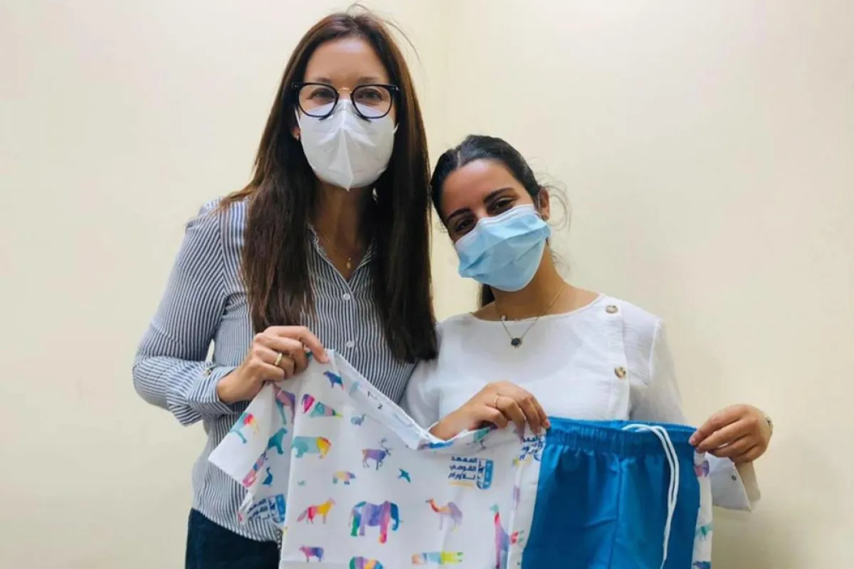 نور النمر تمسك ملابس، وضع تصميمها أطفال مرضى السرطان