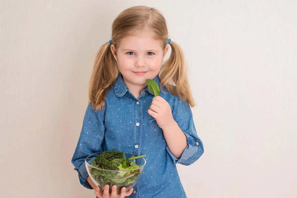 صورة لطفلة تتناول السبانخ