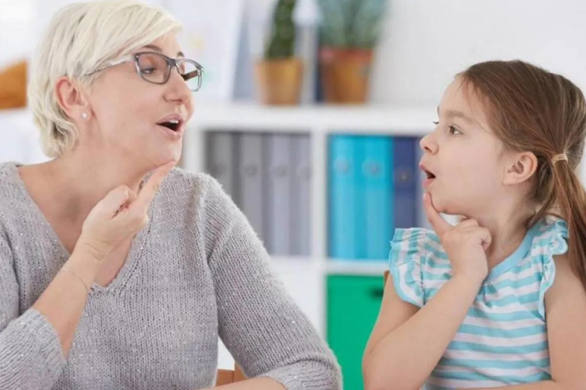  صورة لأم تنطق الحروف لطفلتها