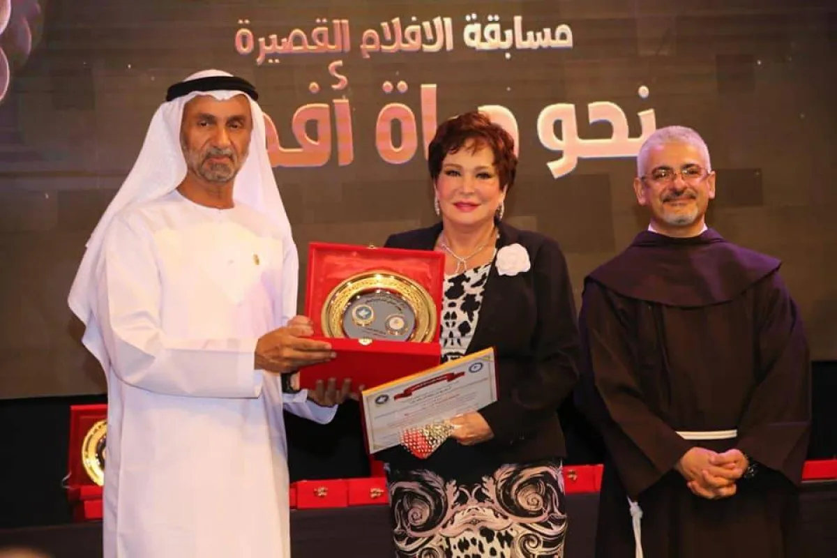  لبلبة تتسلم التكريم من أحمد بن محمد الجروان والأب بطرس دانيال- الصورة من فيسبوك لبلبة