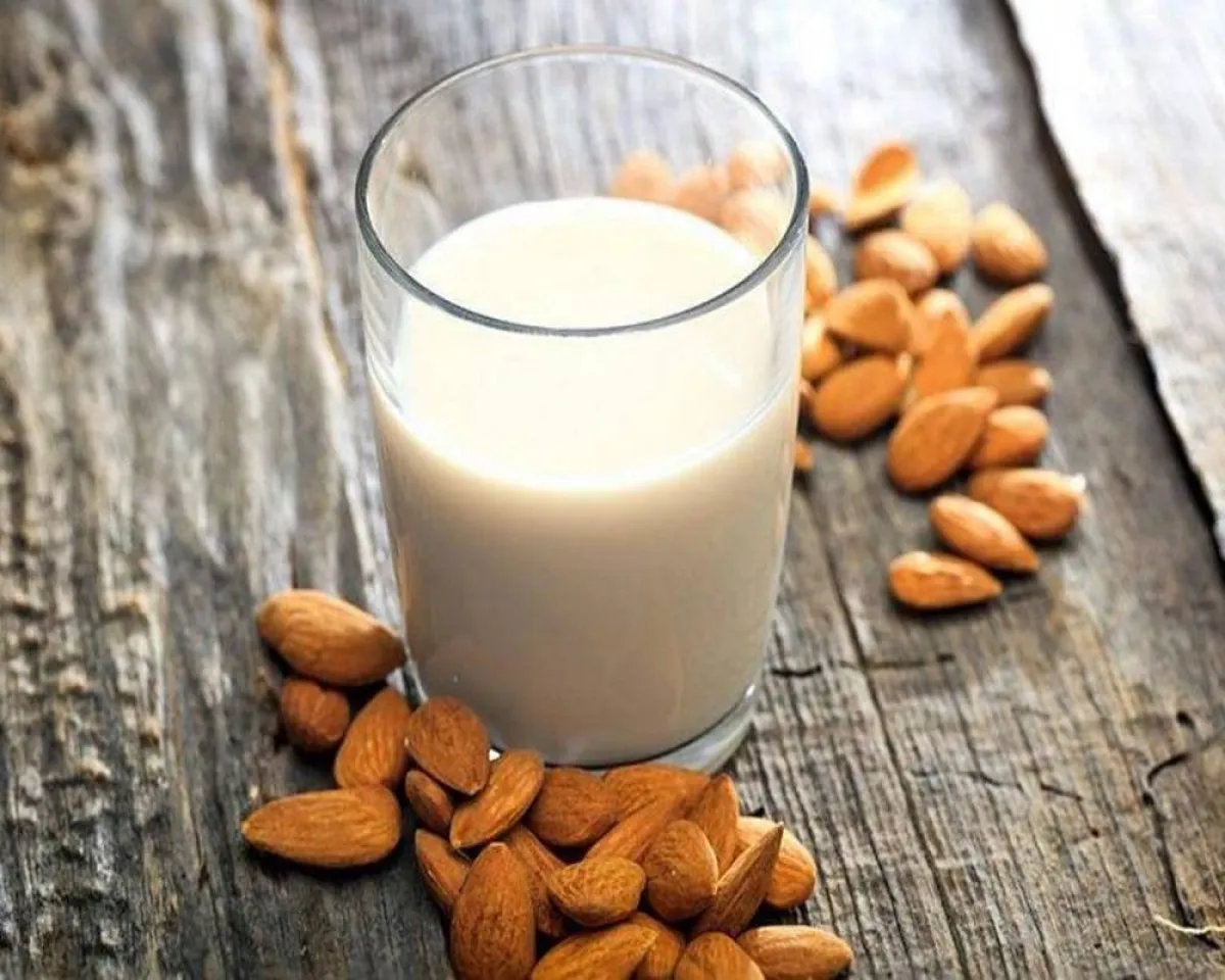 صورة لحفنة من اللوز مع كوب لبن للمرضعات