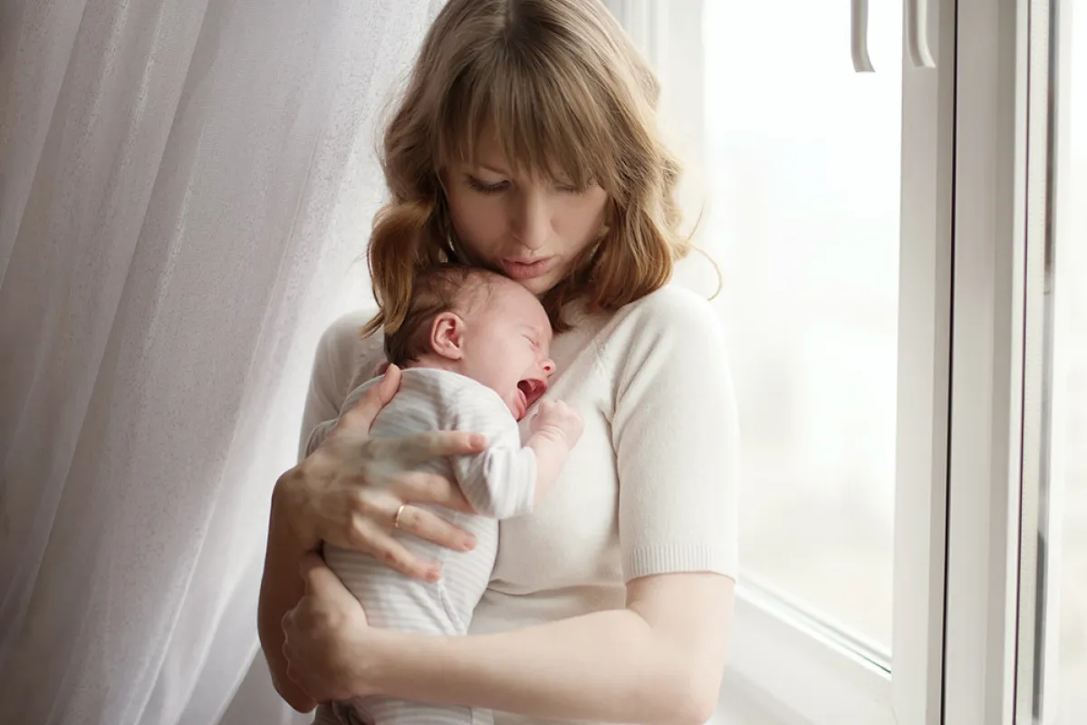 صورة لطريقة حمل الرضيع المصاب بالمغص