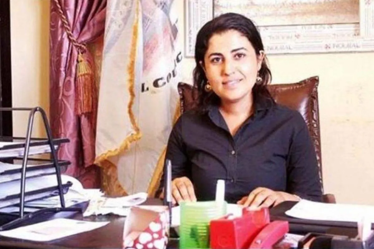 عمدة مدينة تجلس أمام مكتبها تعمل باجتهاد وسعادة