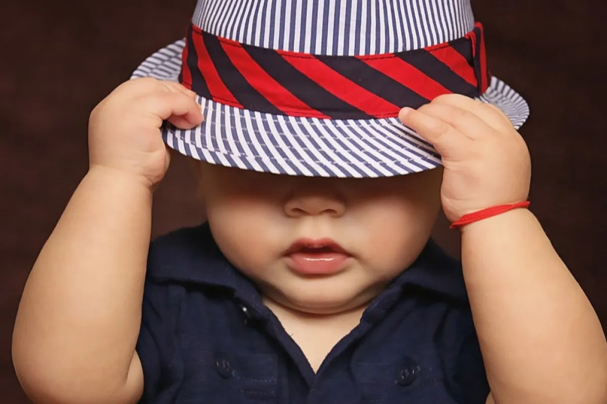 صورة طفل يضع القبعة