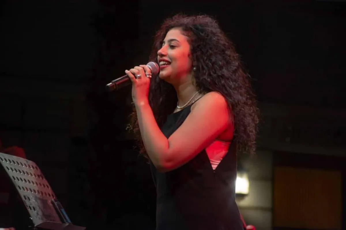 فتاة ترتدي فستان أسود وتغني