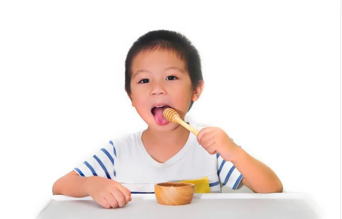 صورة لطفل يتناول العسل