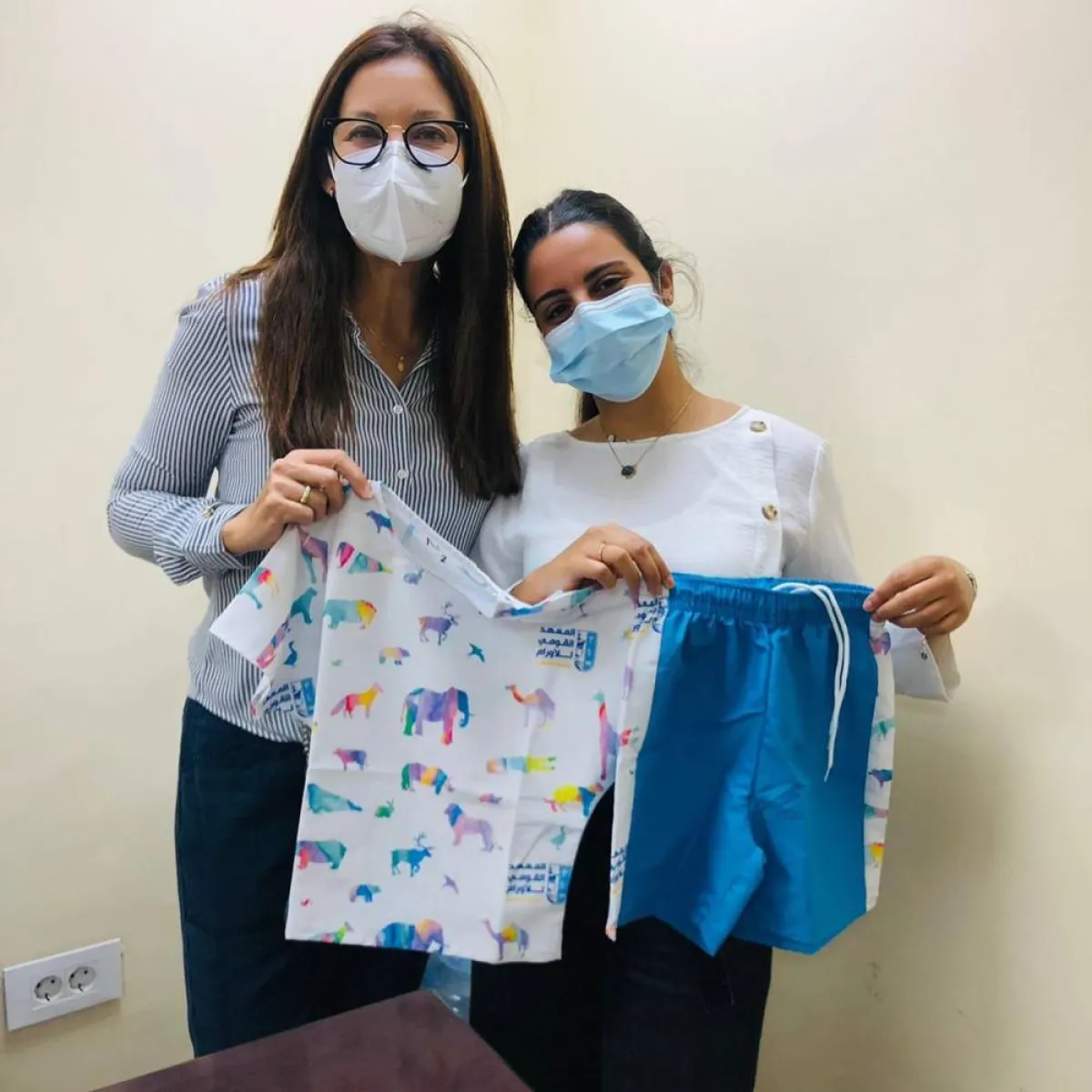 نور النمر تمسك ملابس، وضع تصميمها أطفال مرضى السرطان
