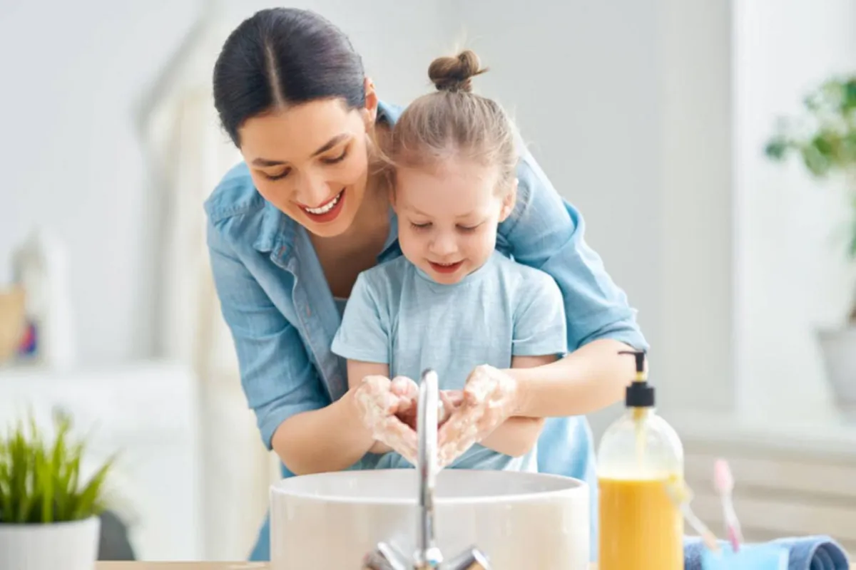 صورة لأم تغسل يد طفلتها