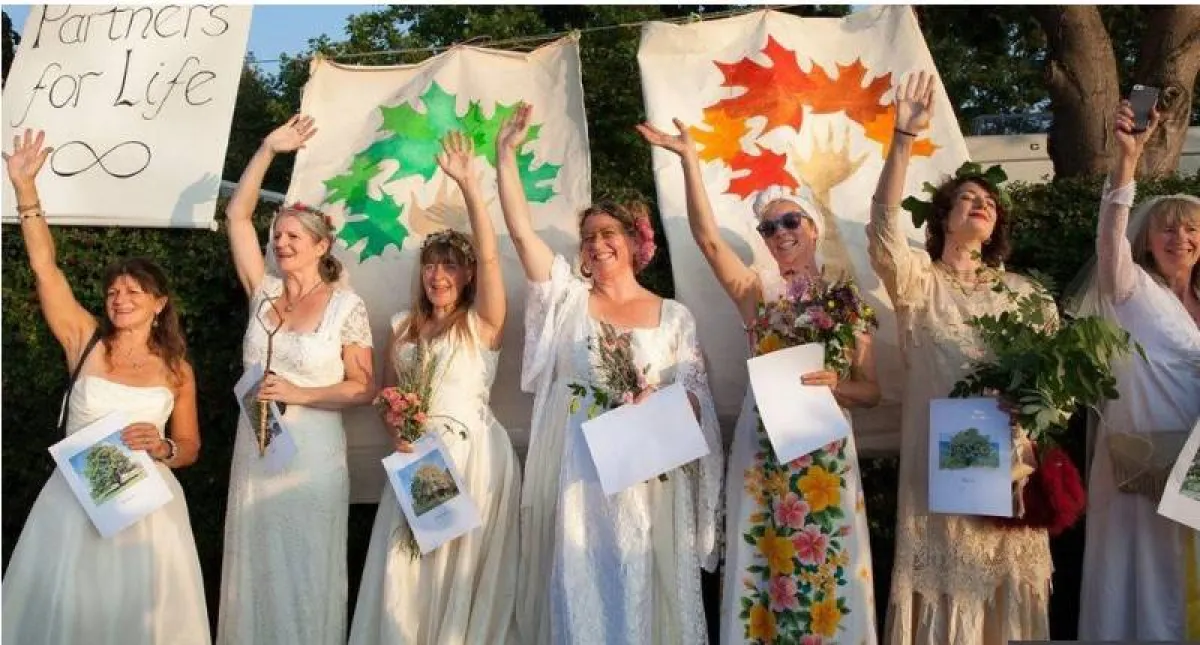 سيدات يرتدين ملابس بيضاء ويحملن صور أشجار