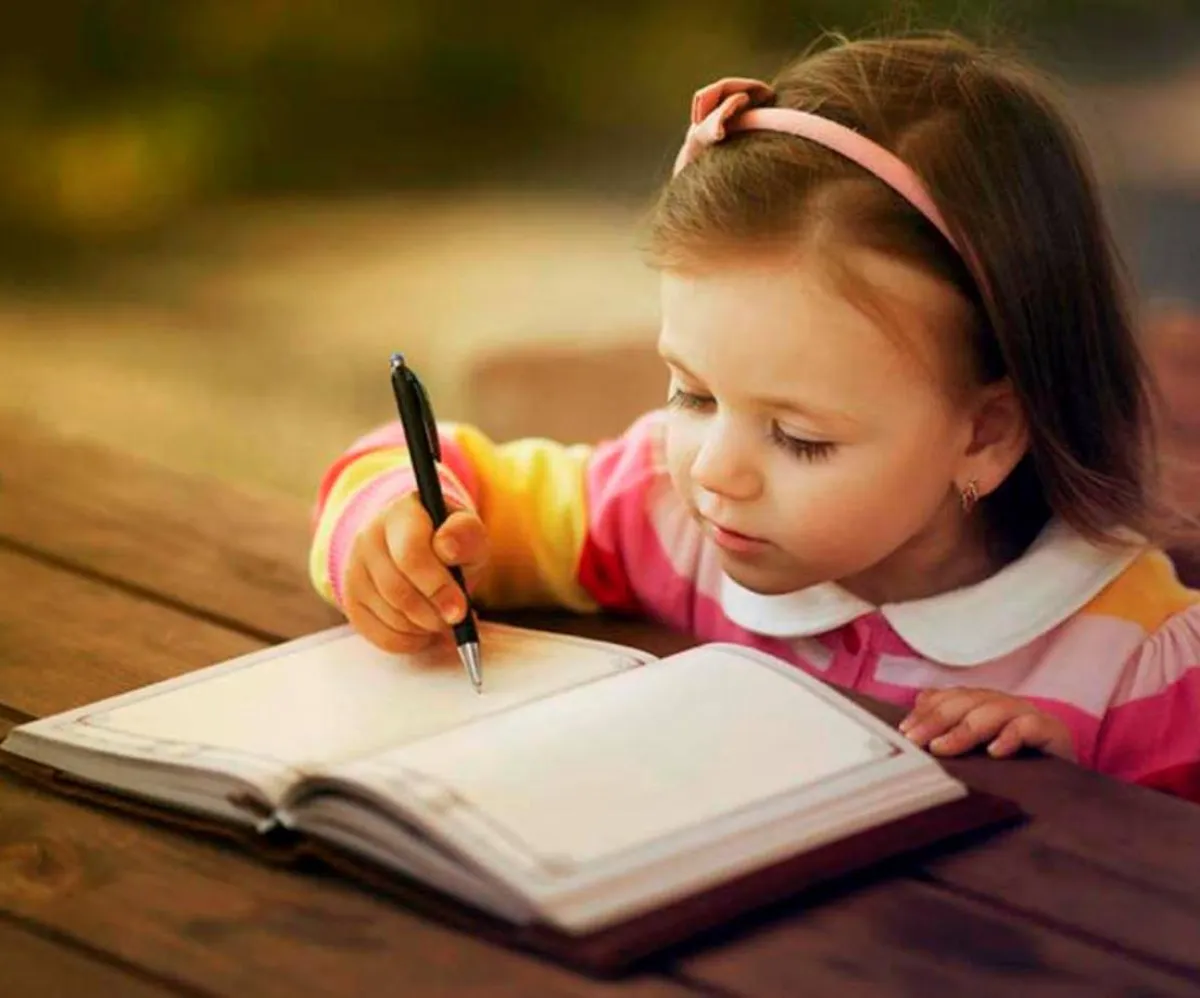 صورة لطفلة مع الورق والقلم