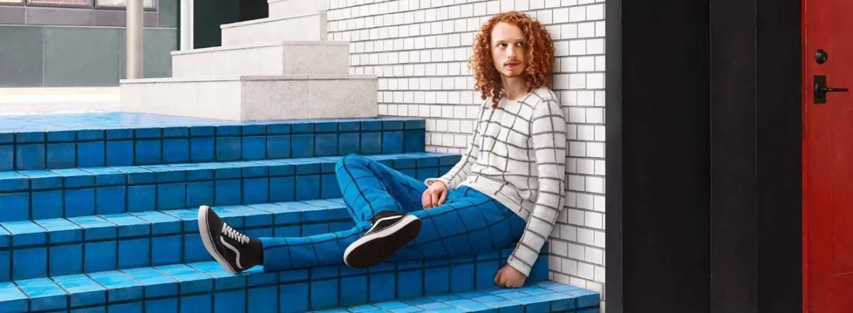 شاب جالس يرتدي ملابس تتماهى مع الخلفية 