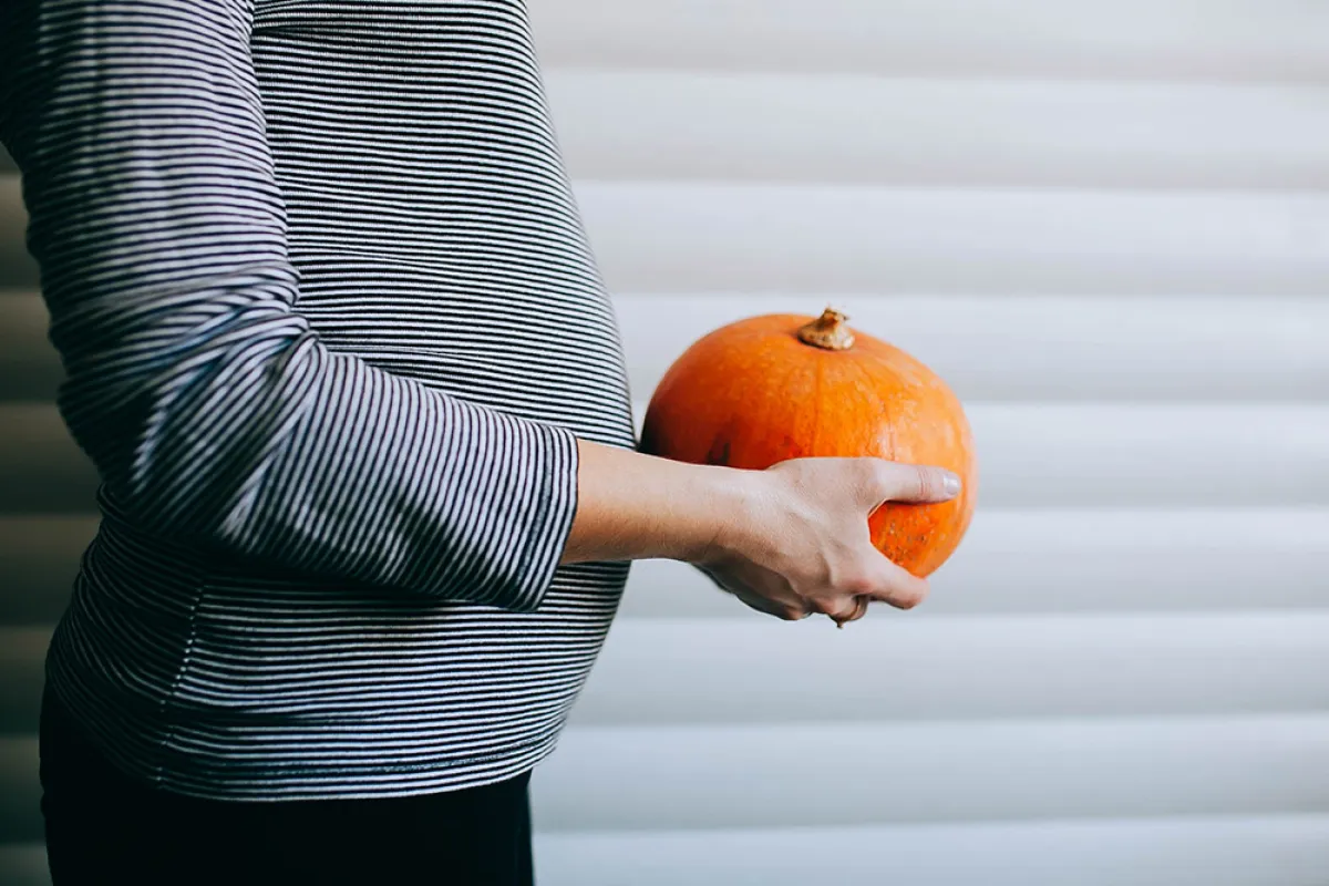 صورة لحامل تمسك بنبات اليقطين