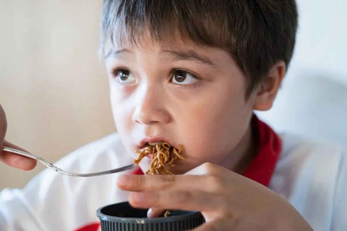 طفل يأكل النودلز بصوص الصويا