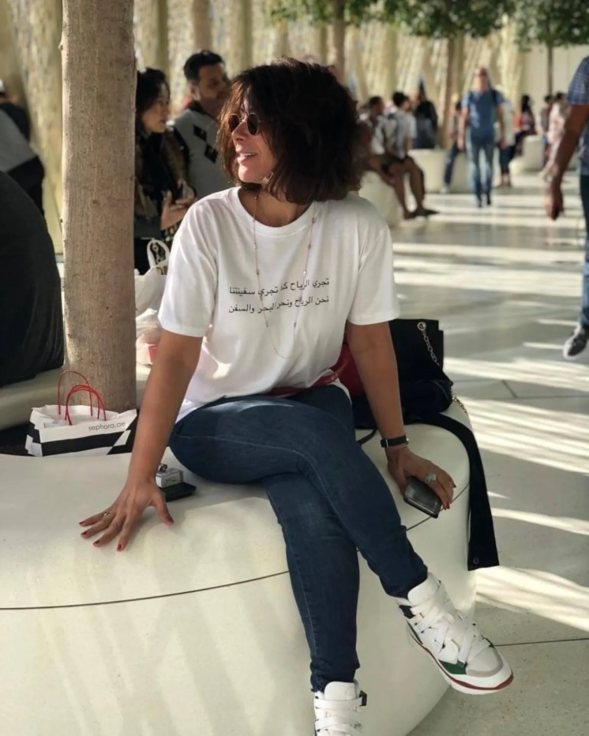 منى زكي بتيشرت أبيض وبنطلون جينز أزرق وحذاء رياضي