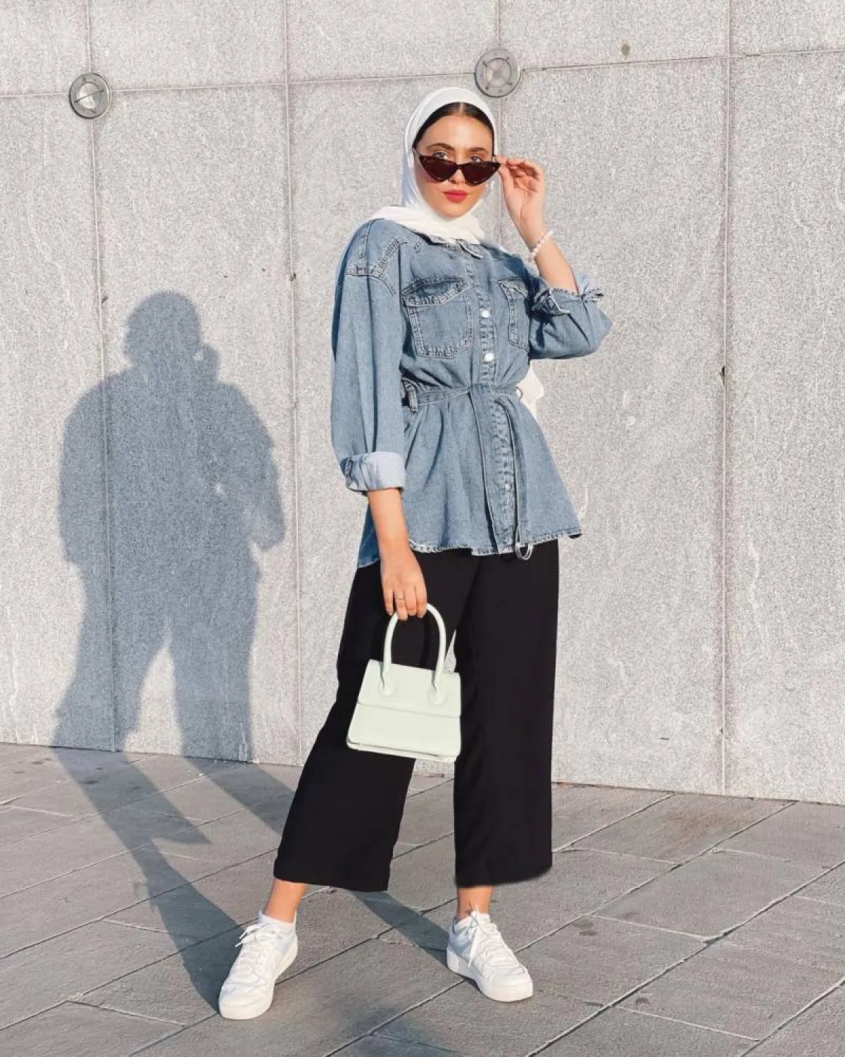 مريم حسن ببنطلون أسود واسع وقميص جينز أزرق