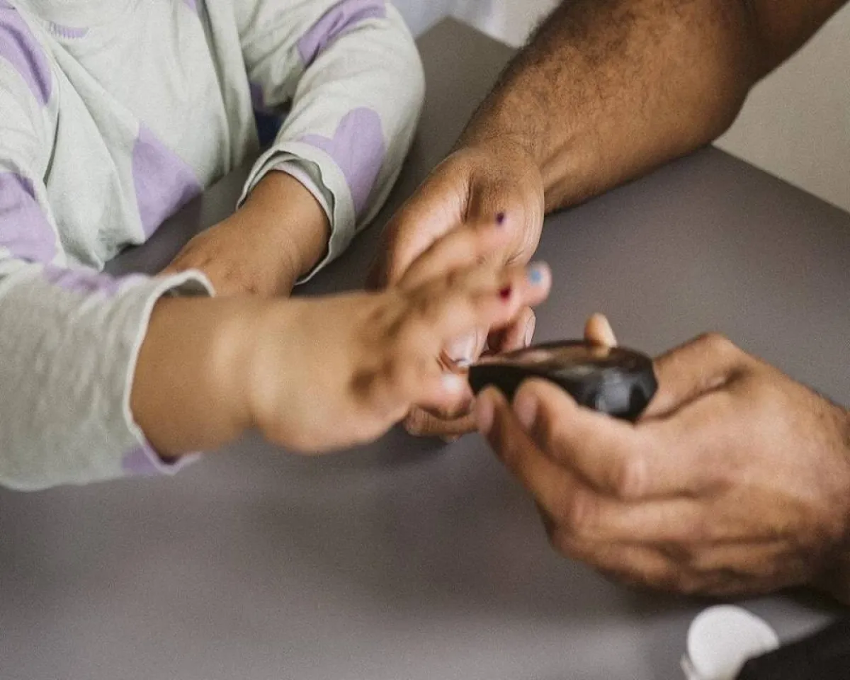 صورة لطبيب يقوم بفحص السكري عند الطفل 