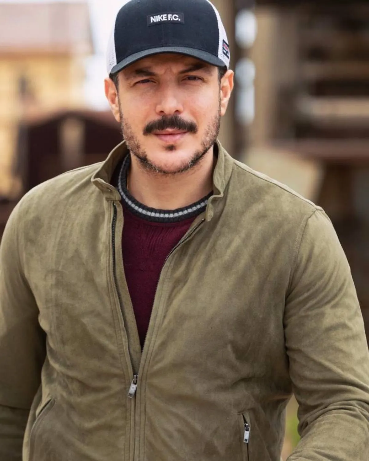 باسل خياط بجاكيت أخضر وبلوفر أحمر داكن