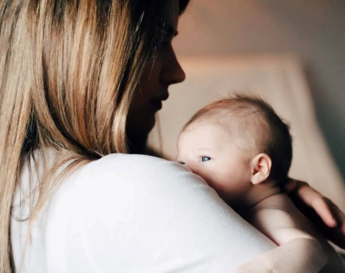 صورة أم تعني بمولودها بعد الولادة