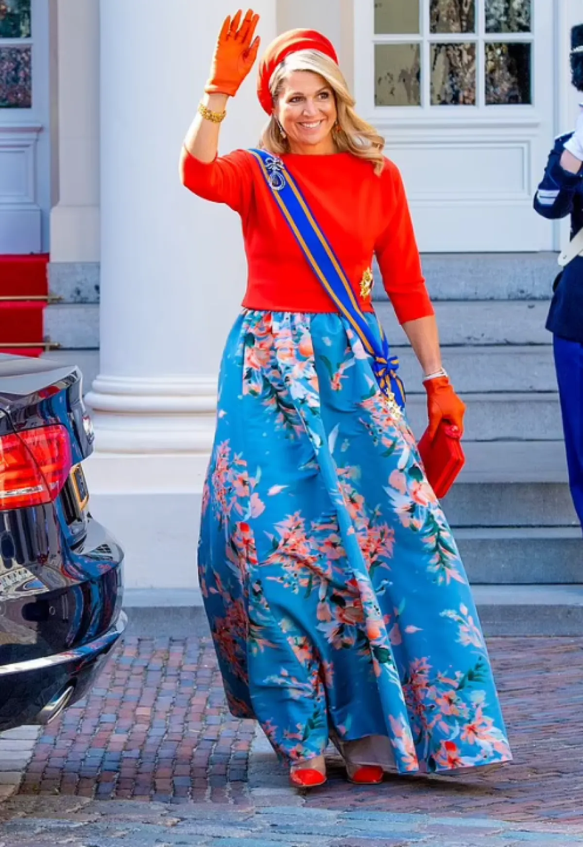 الملكة مكسيما ترتدي كنزة حمراء وتنورة مطبعة