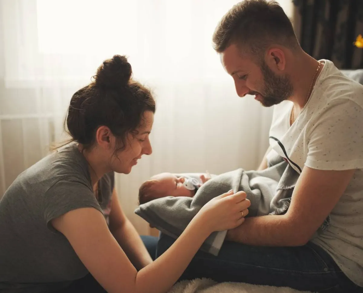 صورة لأبوين يحملان مولودهما