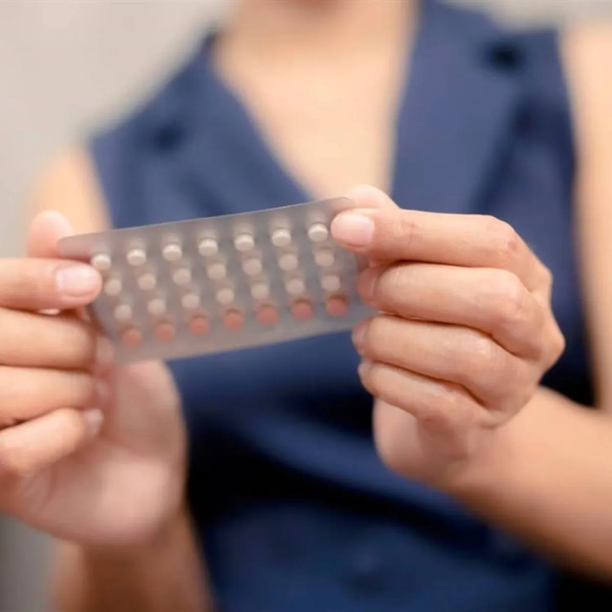 صورة لزوجة تمسك بشريط حبوب منع الحمل
