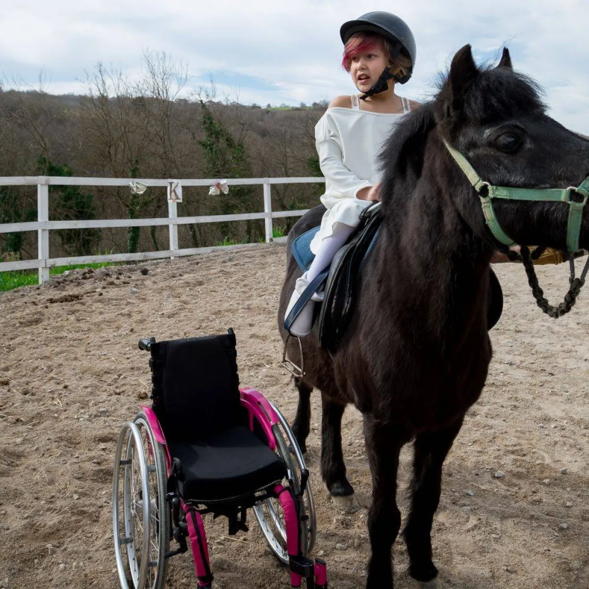 صورة لطفلة من ذوي الهمم تمتطي جواداً