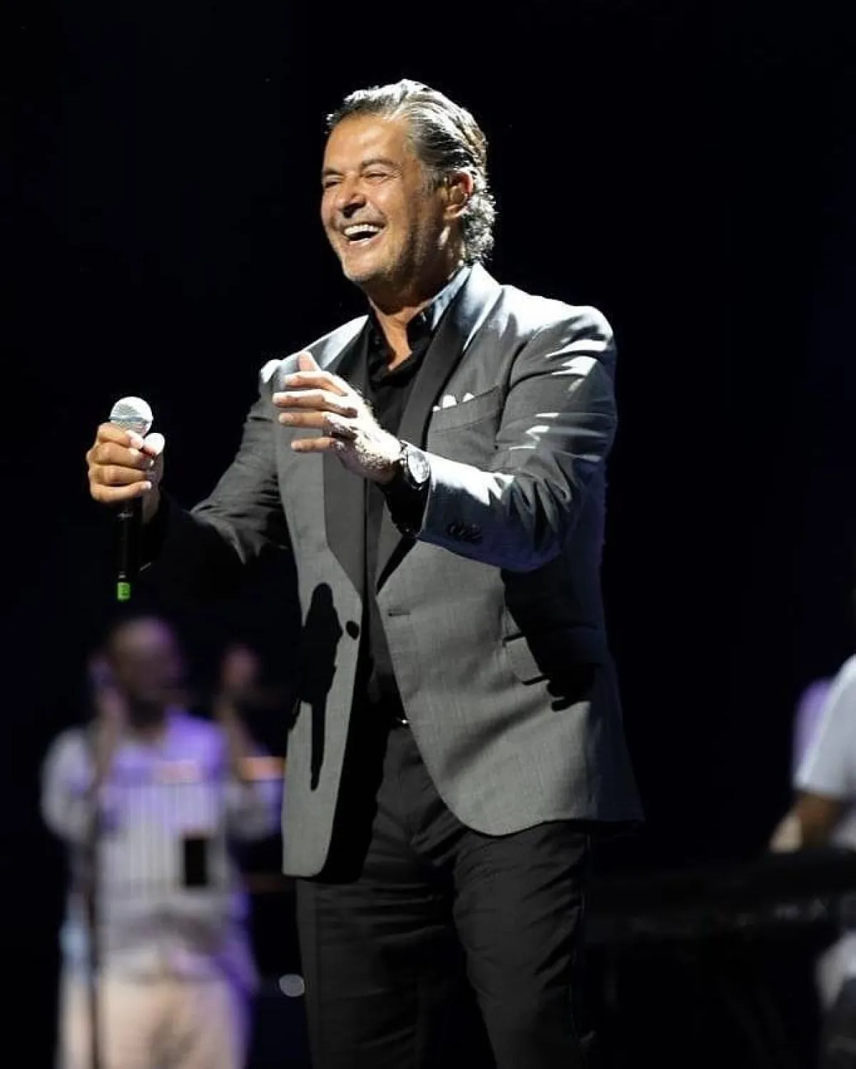 راغب علامة ببليزر رمادي داكن مع قميص وبنطلون أسود 