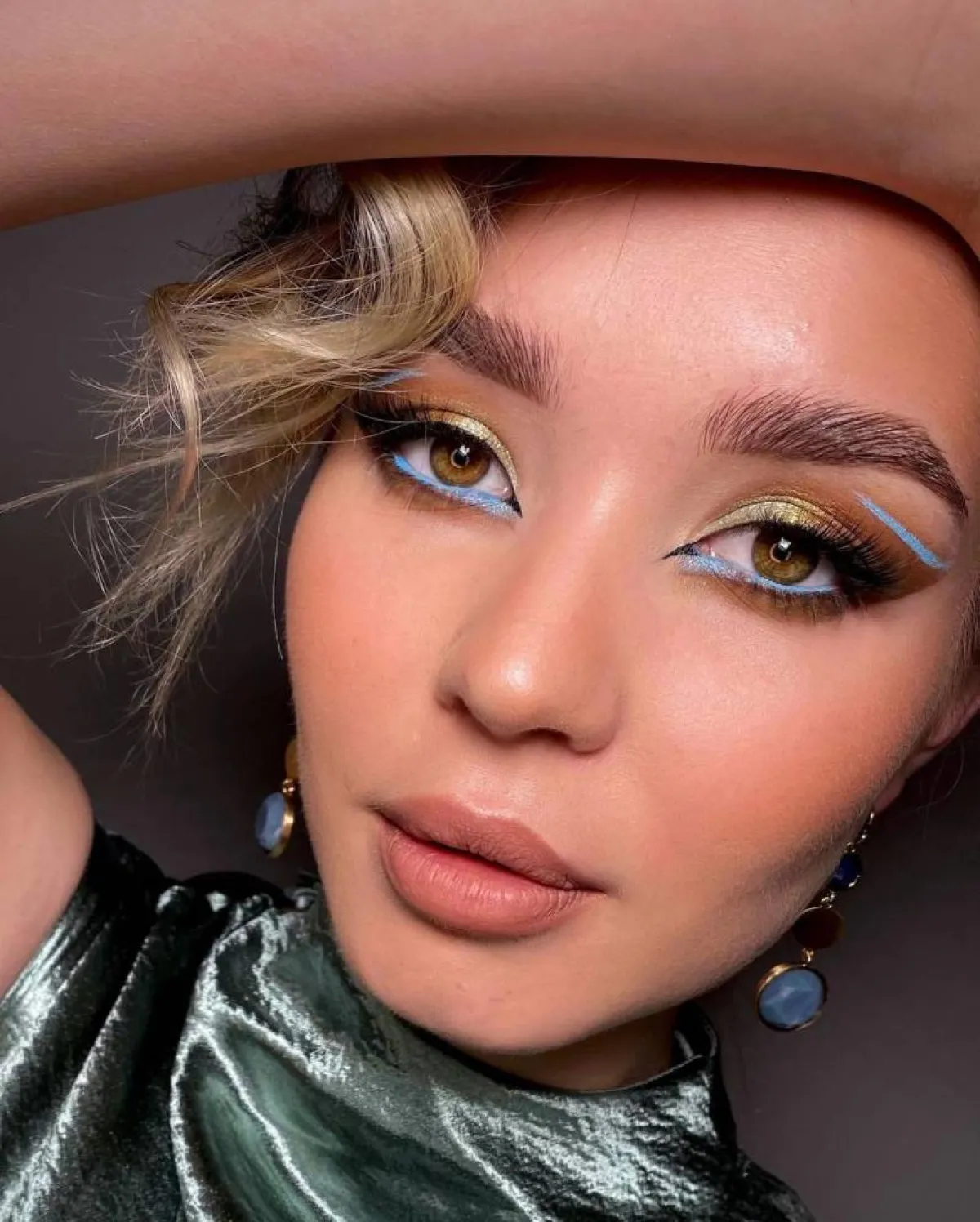 مكياج عيون غرافيكي بظلال العيون الذهبي والأزرق الفاتح
