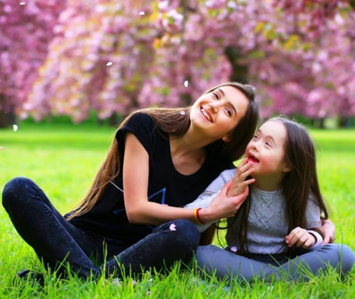 صورة لأم تشجع طفلتها من ذوي الاحتياجات الخاصة